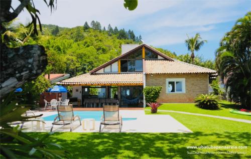 Fachada da casa com piscina e jardim
