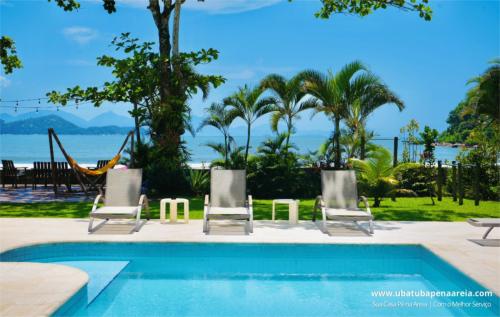 Piscina com palmeiras e o mar ao fundo