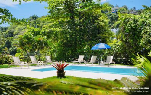 Piscina cercada de jardim tropical