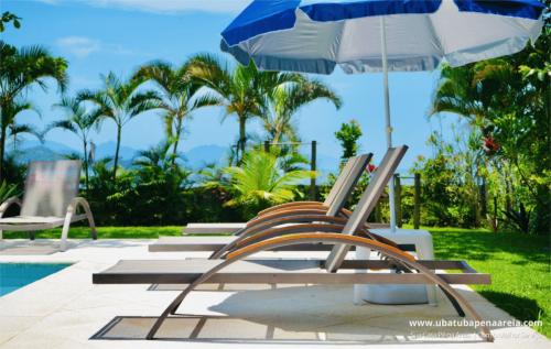 Piscina e jardim com o mar ao fundo
