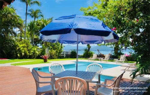 Mesa com guarda-sol ao lado da piscina