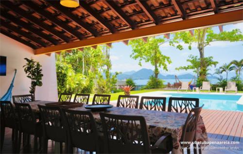 Mesa da varanda com vista para a piscina e o mar